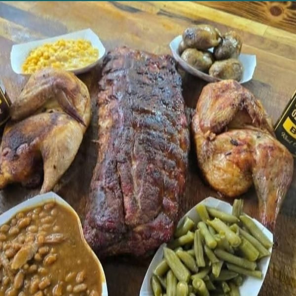 Smokin' Jones BBQ feast with ribs, chicken, baked beans, corn, green beans, and potatoes.